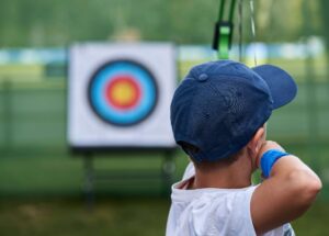 child shooting and bow and arrow at an archery target